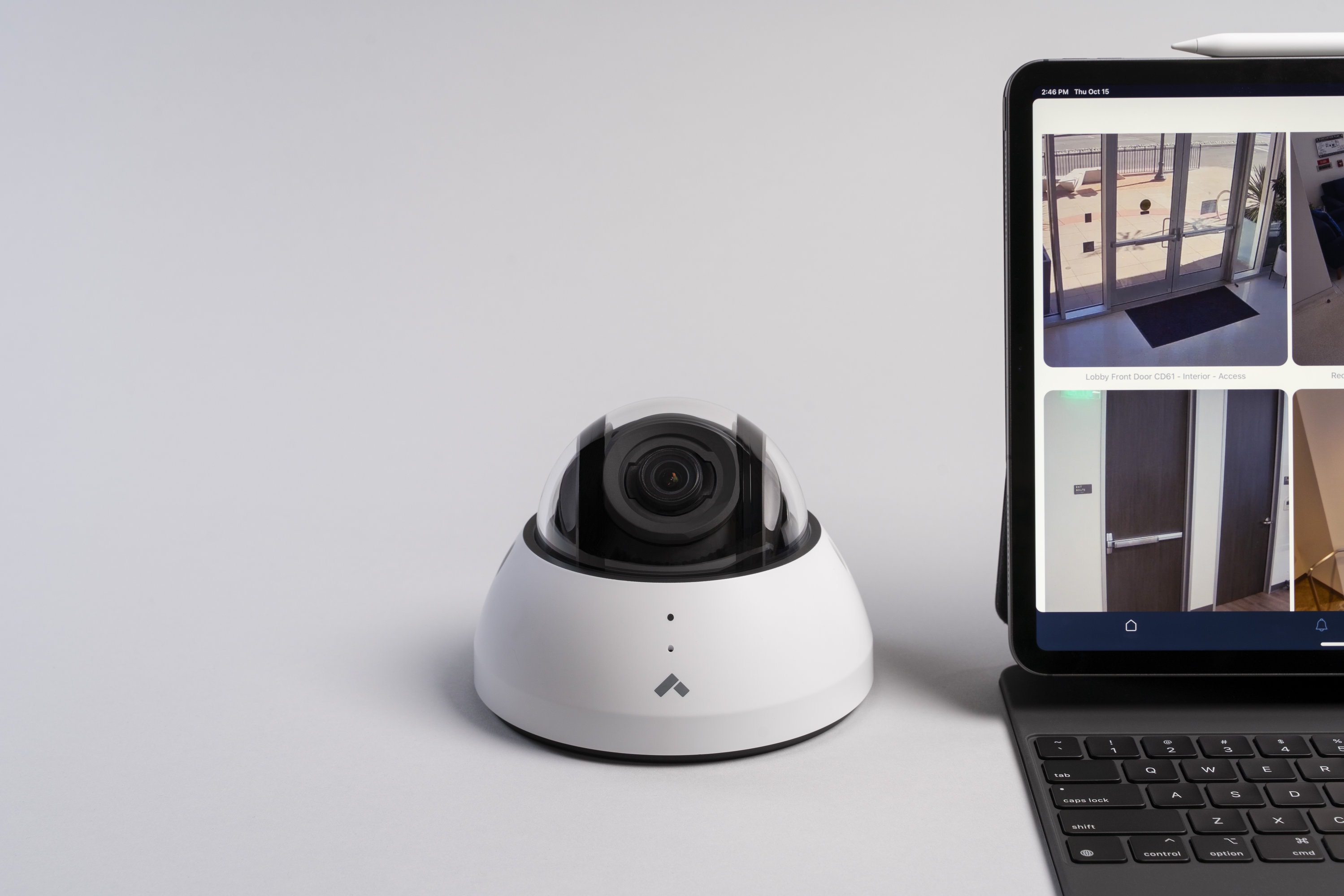 Dome cloud based security camera next to a laptop